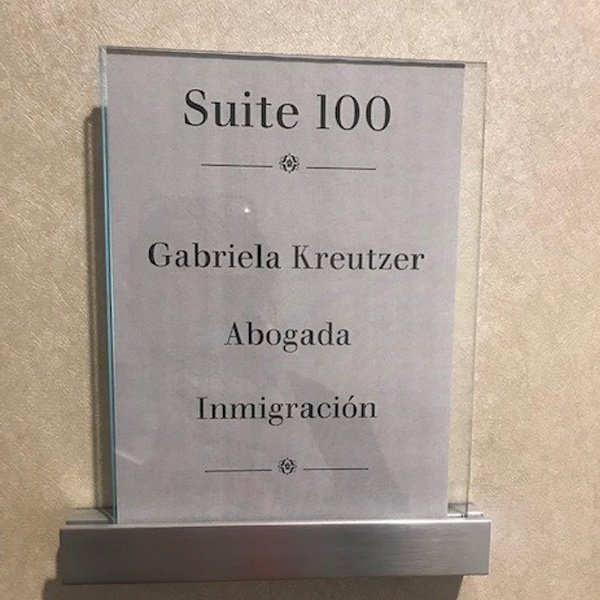 Letrero de la Suite 100 de Gabriela Kreutzer, abogada de inmigración